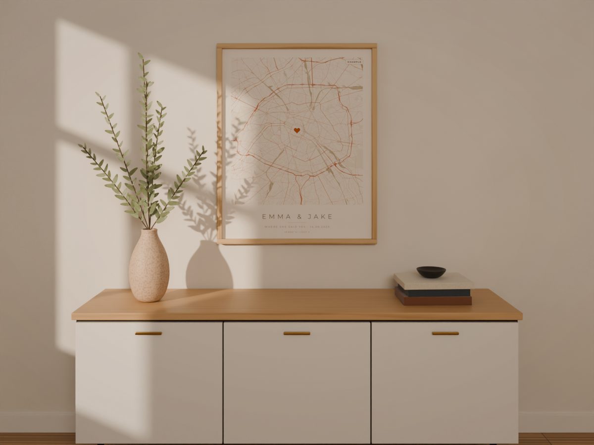 Example personalized map poster of Paris with a heart on the spot and the words Emma and Jake, framed above a sideboard